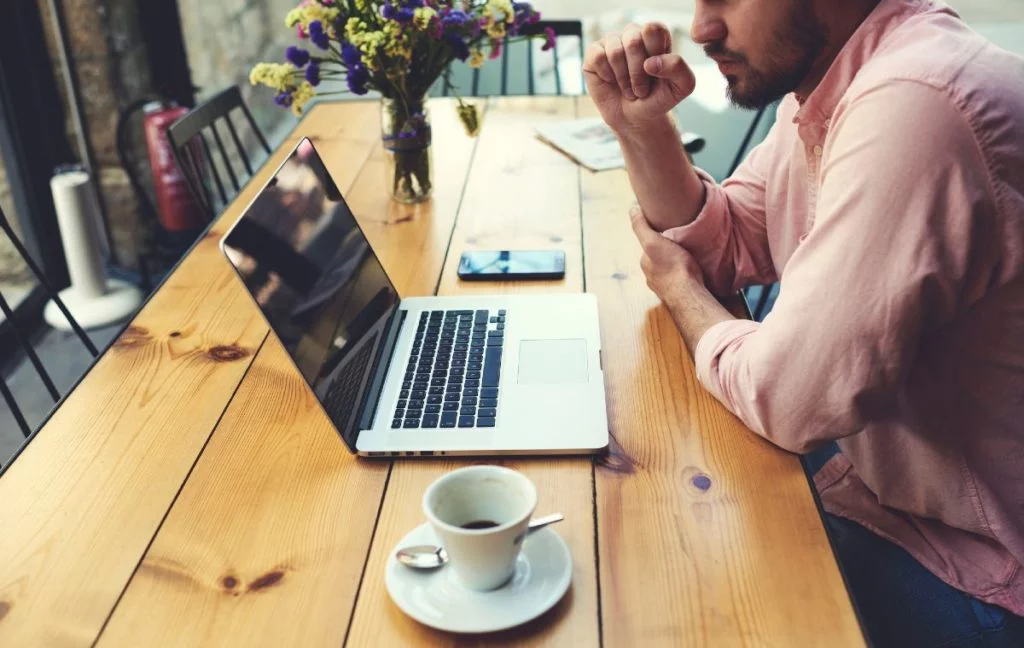 Man enjoying a cup of coffee in the morning with his laptop